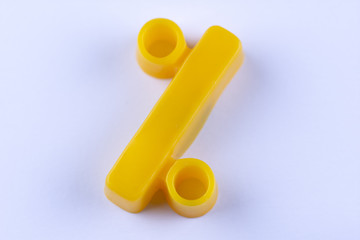 isolated yellow percent sign made of plastic on white background with shadows