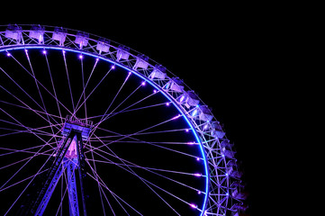 Big ferris wheel with festive purple illumination