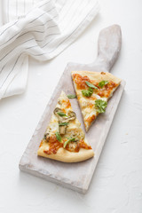Two pieces of cheese pizza on white cutting board