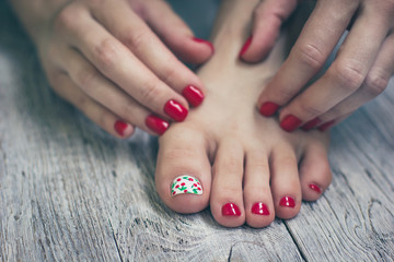 Obraz na płótnie Canvas Red manicure and pedicure on vintage wooden background