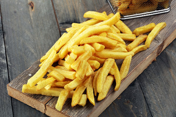 Tasty french fries on wooden table background