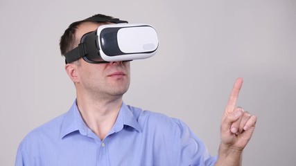 Business man wearing virtual reality goggles headset, vr box. Connection, technology, new generation and progress concept. Slow motion. Studio shot on grey