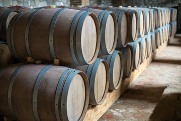Wine barrels stacked in the old cellar of the winery.