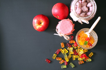 Marmalade in a vase on the table. Sweets in a bowl on a black ba