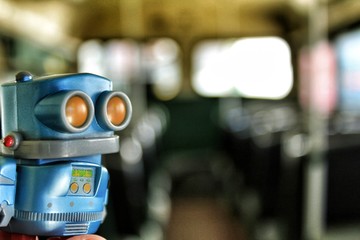 Fototapeta na wymiar Toy robot inside old bus school