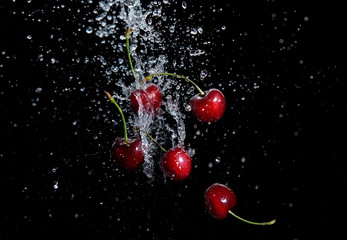 juicy red cherries in water splash on black background - 209787556