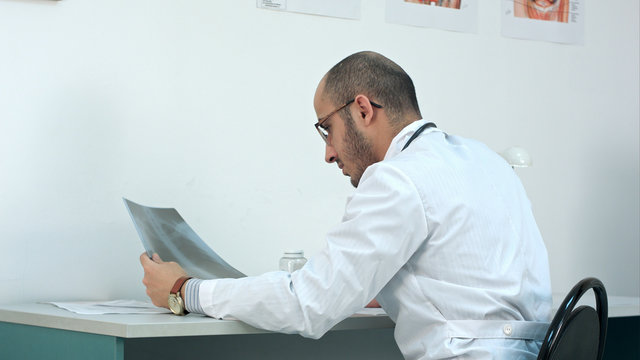 Young male doctor examining chest xray image