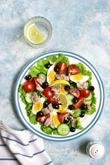 Tuna salad with cherry tomatoes, cucumber, black olives and boiled eggs.Top view.