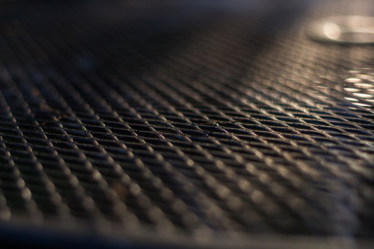 Thin Line Of Focus On A Black Metal Table Top With Sunlight In The Background.