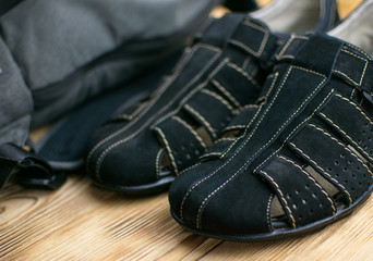 Fototapeta na wymiar men's sports black suede sandals on a wooden background