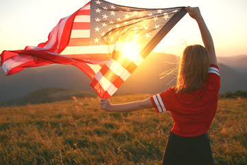 happy woman with flag of united states enjoying the sunset on nature