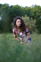 Fototapeta premium Young, beautiful woman on nature. Young woman with dark curly hair.