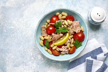Tuna salad with cherry tomatoes and white bean.Top view with copy space.