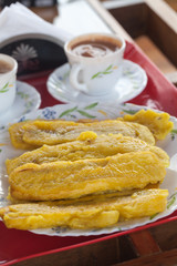 Yellow sliced plantain banana fry, fried in pan with hot coconut oil and two cups of masala tea, Kerala, India