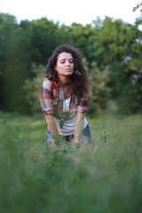 Fototapeta premium Young, beautiful woman on nature. Young woman with dark curly hair.