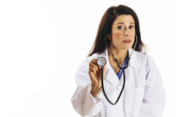 Portrait of a serious female doctor holding stethoscope and looking at camera, isolated on white studio background 