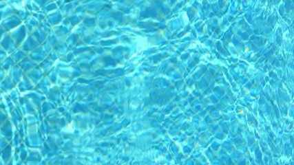 Blue water in swimming pool. Waves and patches of sunlight appears on the bottom of the pool. Glares blinks and reflections on clear water. Vertical format video. - Powered by Adobe