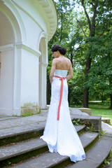 Fototapeta premium Beauty bride in bridal gown with lace veil in the nature