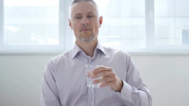 Businessman Drinking Water in Office