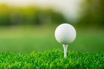 Foto op Canvas close up the golf ball on tee pegs ready to play in the green background © lamyai