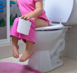 A child is sitting on the toilet
