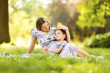 Mother and son on blanket in park