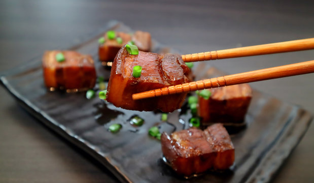Braised pork belly oriental style food appetizer on dark background. Selective focus.