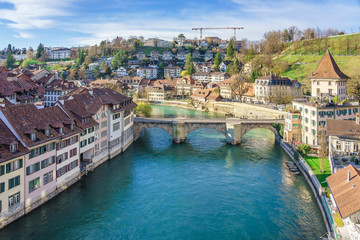 Fototapeta na wymiar Bern, Switzerland. View of the old city center and Nydeggbrucke bridge over river Aare.