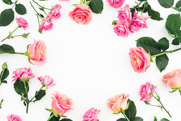 Floral frame composition with roses flowers, buds and green leaves on white background. Flat lay, top view