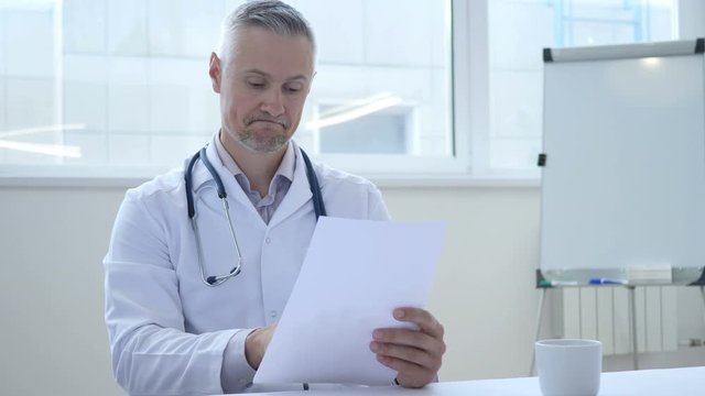 Sad Doctor Reading Medical Report of patient