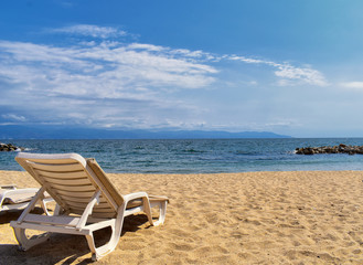 Fototapeta na wymiar Beach, city and ocean view in Puerto Vallarta Mexico with beach chairs and coastline.