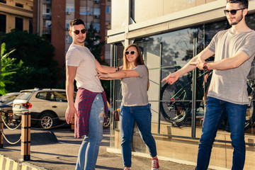 Fototapeta premium Group Of Friends Standing On The Sidewalk Near The Street