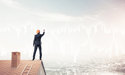 Man architect draw silhouette of modern city on blue sky. Mixed 