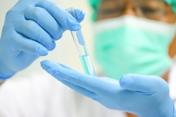Scientist or researcher holding a test tube in a laboratory.