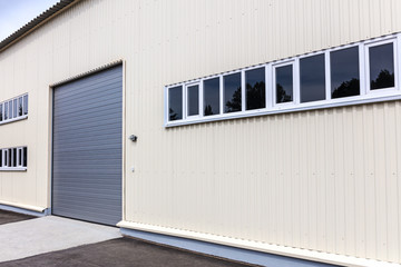 new storehouse building wall with closed roller shutter gate
