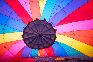 Fototapeta premium Rainbow-Colored Hot Air Balloon Begins to Fill Up with Air Before Taking Flight