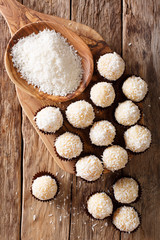 Brazilian Coconut Kisses (Beijinhos de Coco) condensed milk and coconut flakes close-up. Vertical top view