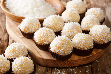 Delicious Brazilian sweets beijinhos de coco with condensed milk and coconut close-up. Horizontal
