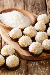 Delicious coconut kisses( beijinhos de coco or branquinhos)  - festive Brazilian sweets close-up. vertical