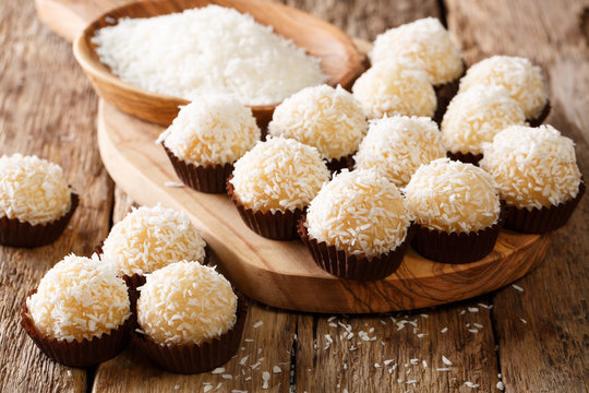 Appetizing candy balls beijinhos de coco with condensed milk and coconut close-up. horizontal