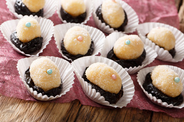 Home children candy Olho de sogra from condensed milk, plum and coconut sugar close-up. horizontal