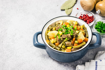 Vegetables and meat stew in a pot. Selective focus, space for text.