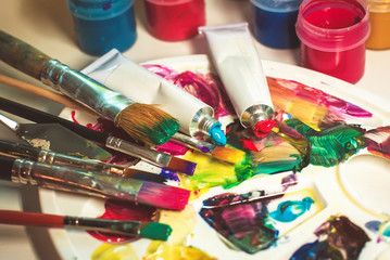 group of used brushes and a color palette. artist set of ideas of creative inspiration. a palette with paint and brushes