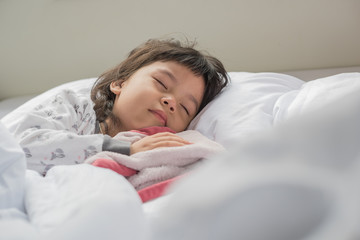 Children sleeping on a white bed with happiness.