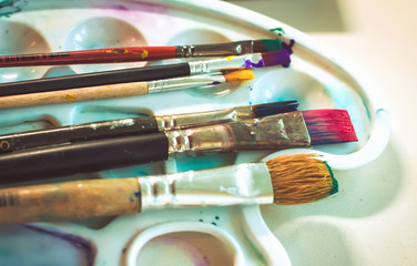 creative image, artist's palette with oil paints and brushes,