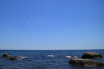 Fototapeta na wymiar Image of the sea shore. A water motorcycle tows a parachutist.