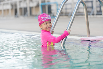 Child having fun in swimming pool. Kid playing outdoors. Summer vacation and healthy lifestyle concept