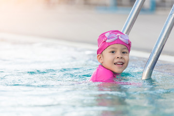 Child having fun in swimming pool. Kid playing outdoors. Summer vacation and healthy lifestyle concept