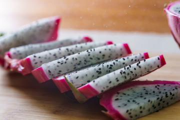 Cutting Fresh Pitaya or Dragon Fruit On Wooden Table