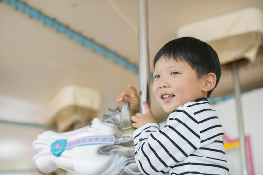 メリーゴーラウンドに乗っている男の子